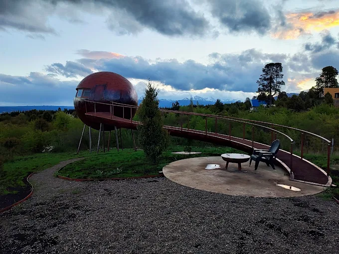 Esfera elevada al atardecer con pasarela curva